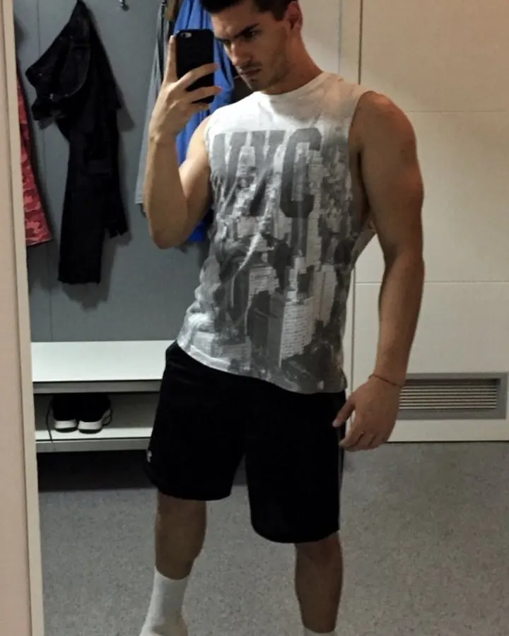 Homme torse nu, en sous-vêtements, debout près d'une fenêtre, regardant vers l'appareil photo, dans une ambiance naturelle et douce.