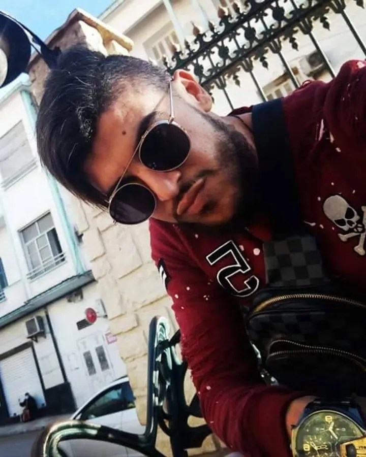 Homme européen torse nu, prenant un selfie en extérieur, regardant vers le haut, en short noir