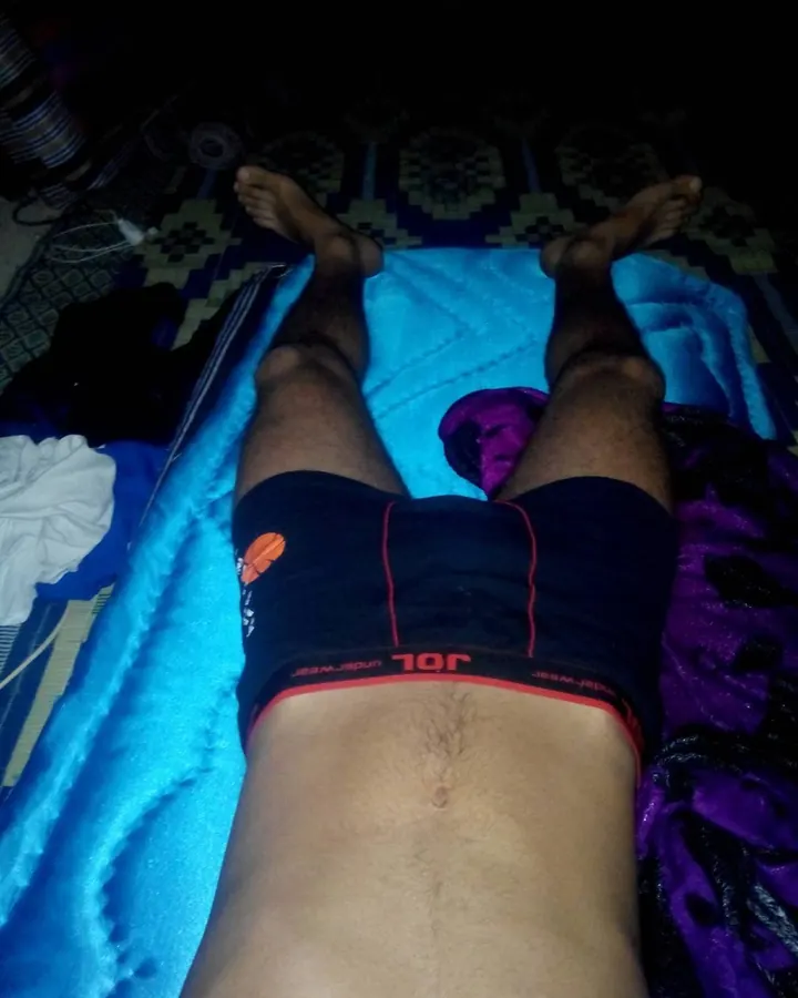 Homme européen torse nu, allongé sur un lit, regardant vers le haut, jambe repliée