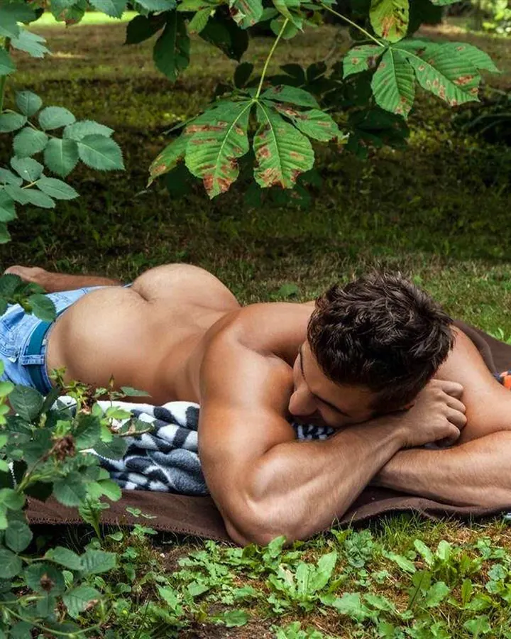 Homme européen torse nu, se tenant debout, regardant vers le bas, lumière naturelle