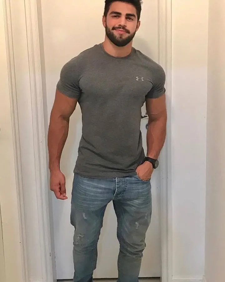 Homme arabe torse nu, se tenant debout, regardant vers le bas, lumière naturelle