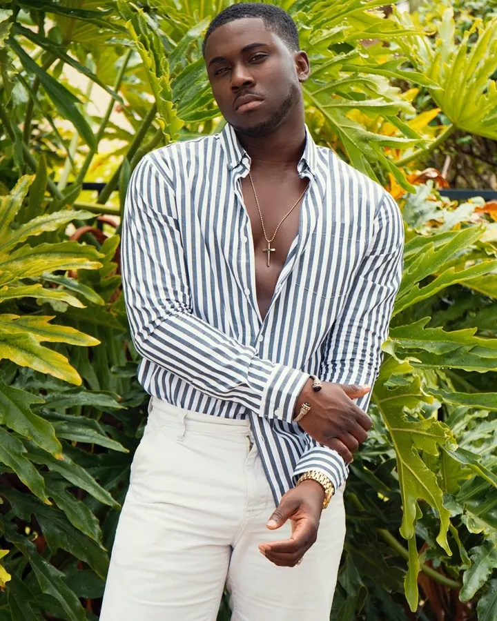 Homme africain torse nu, musclé, en sous-vêtements noirs, posant devant un fond blanc.
