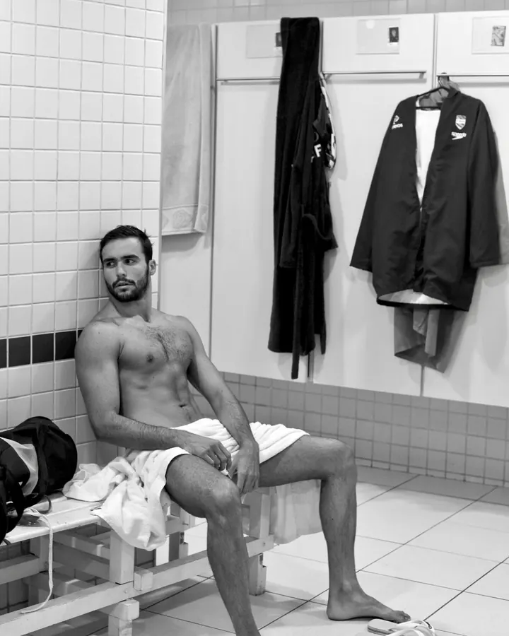 Homme torse nu, debout, regardant directement l'appareil photo, avec une main sur la hanche.