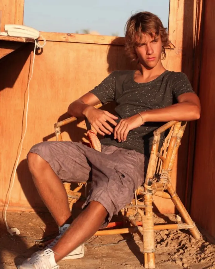 Homme torse nu, debout, regardant directement l'appareil photo, avec une main sur la hanche.