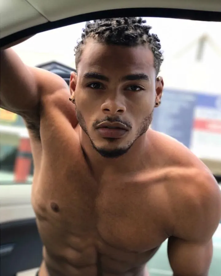 Homme torse nu, barbu, regardant vers le haut, main sur la tête, lumière vive derrière lui